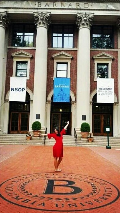 Tatiana Vera stands behind the Barnard seal at the campus gates during the New Student Orientation Program