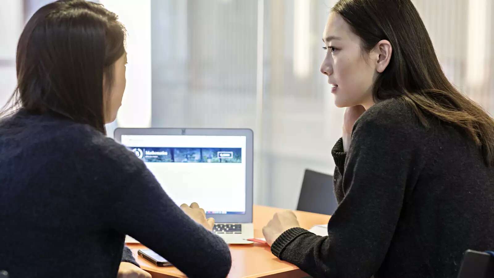 2 women students working together on a laptop